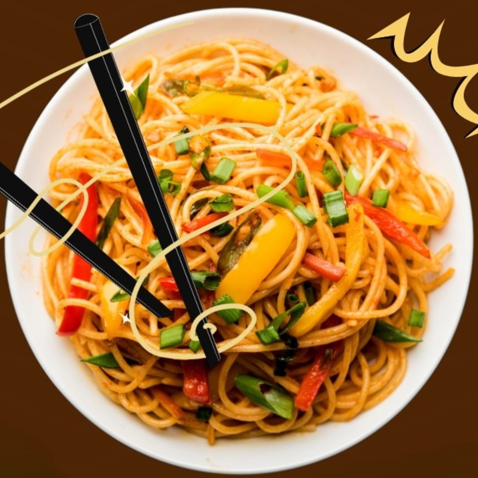 A white bowl of Indian noodles with colorful vegetables and green onions, with chopsticks.